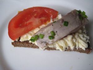 Бутерброды с селедкой, помидорами и плавленым сыром на черном хлебе на праздник 